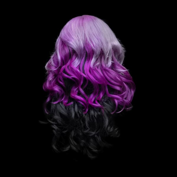 Framed photograph by Stephane Alexis titled "Wig No.3" 2022. Rear view of a wig against a black background styled into loose curls with 3 layers of color. Stating with lavender on top, then bright purple then black.