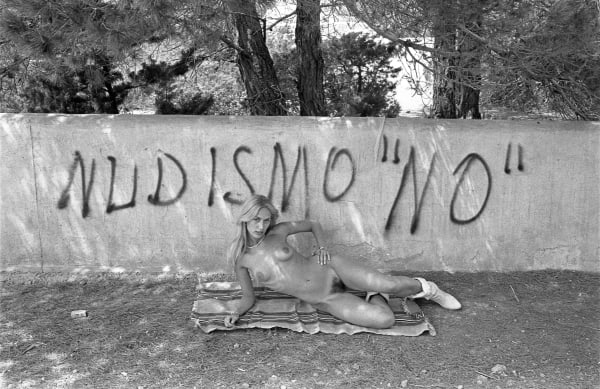 Oriol Maspons, Eva Lyberten in front of Nudisimo "No" sign, Ibiza, cerca 1980