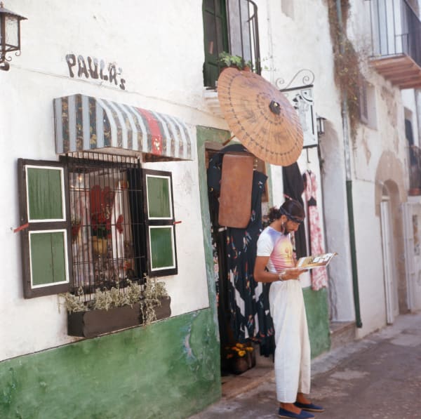Walter Rudolph, Stuart Rudnick Founder of Paula´s Ibiza Reading a magazine, Ibiza, Spain, 1976