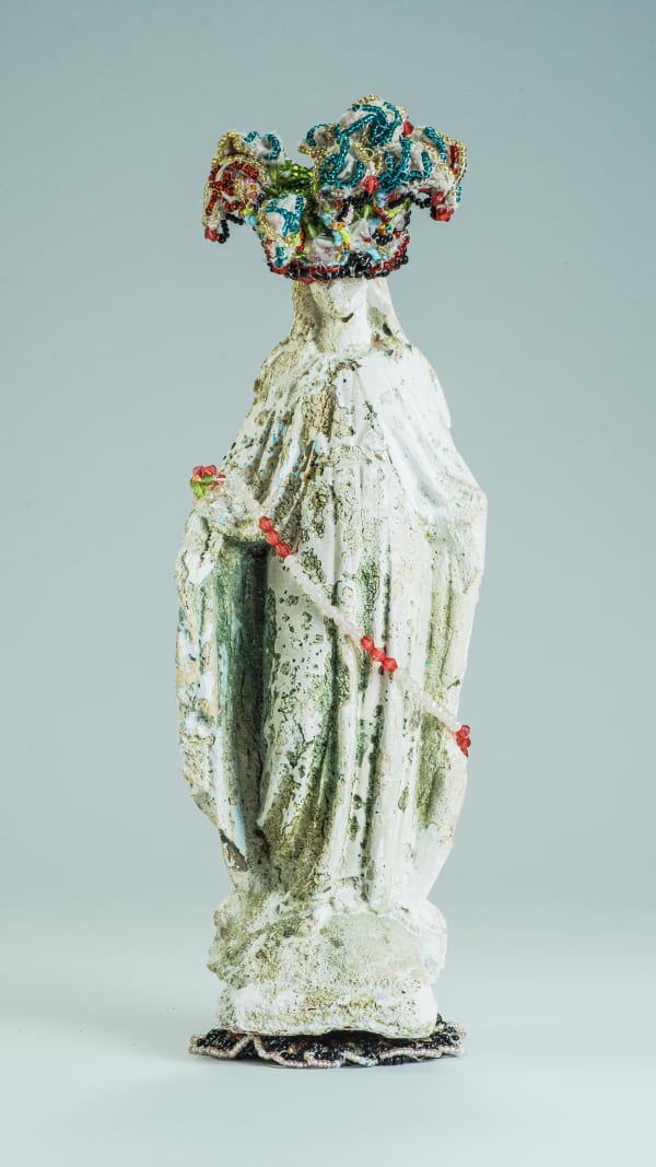 A sculptural work made with multiple mediums depicting a broken statue of an idol made with plaster of paris that is ornamented with colourful glass and plastic beads in order to heal the bad omens associated with damaged figurines and thereby Sri Lanka political scenario
