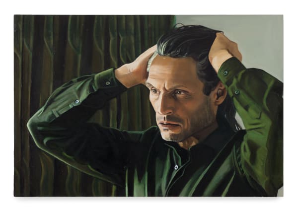 Man framför grönt draperi