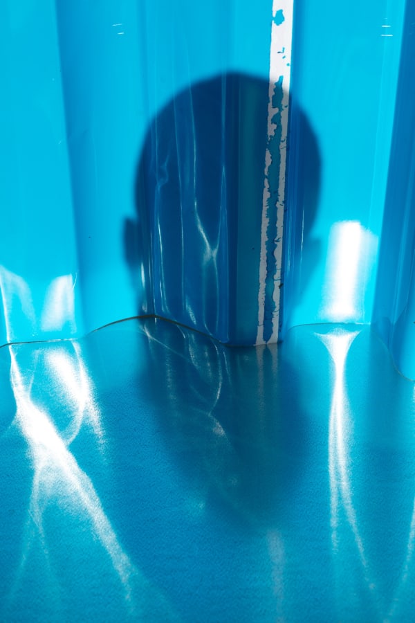 Wolfgang Tillmans self-portrait in shadow over reflective, bright blue acrylic material
