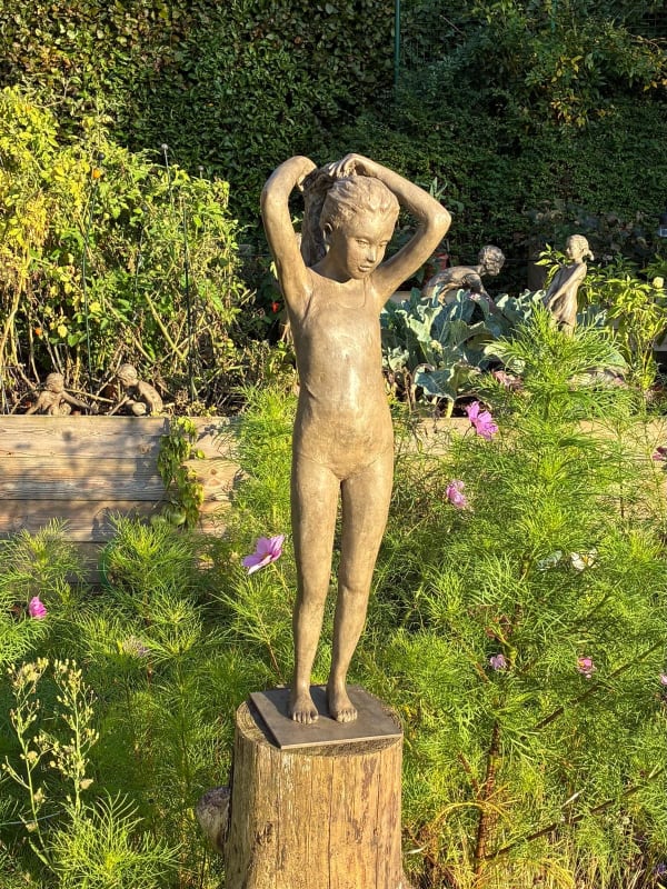 sculpture en bronze, La Petite Baigneuse, Béatrice Cols, artiste belge, enfant en bronze, jeune fille en maillot, figurative, coiffure en couette, patine naturelle, sculpture poétique, art contemporain, décoration intérieure, sculpture de jardin, bronze patiné, collection d’art