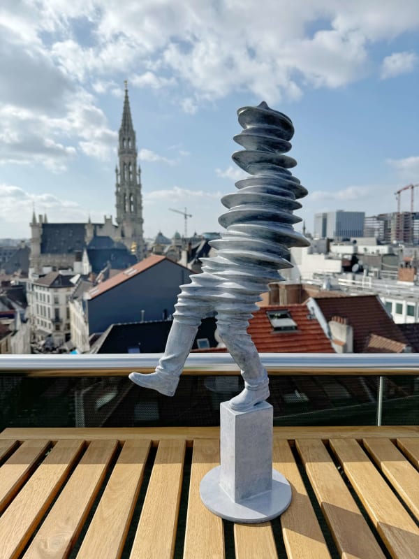 Walkman sculpture contemporaine Liang Binbin une sculpture en bronze gris clair représentant un homme marchant et sautant sous la pluie avec une ombre sculpture figurative Galerie Art Yi Galerie d'art de Bruxelles