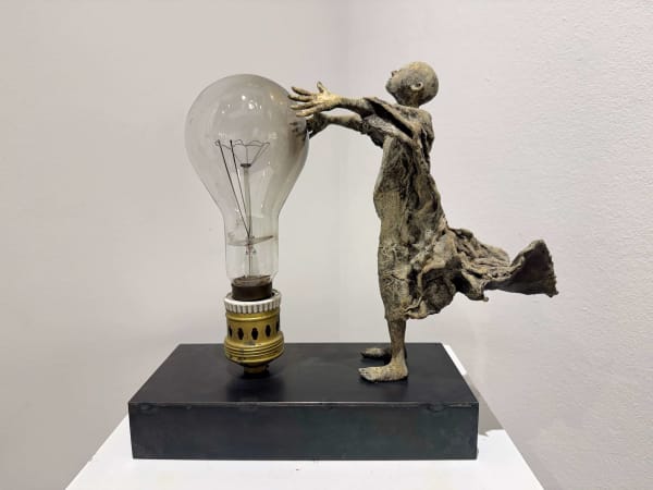 Visionary XL, sculpture lumineuse en bronze de Lieven d'Haese représentant un garçon ouvrant les bras pour allumer une ampoule, symbole d'imagination, de magie et de rêve. Sculpture d'art contemporain, design lumineux et design d'intérieur, exposée à la galerie Art Yi à Bruxelles.