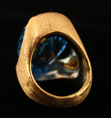 18 Karat Gold Ring with a Florentine Finish Featuring a Blue Topaz