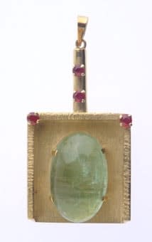 Gold Pendant in the Shape of a Mahta Featuring an Emerald