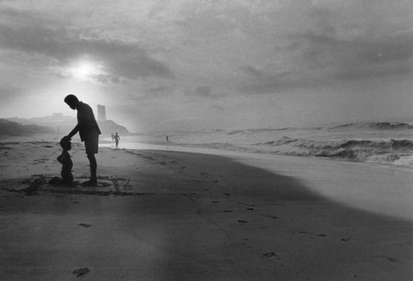 Father prays over son on Osu Beach, Accra, Ghana