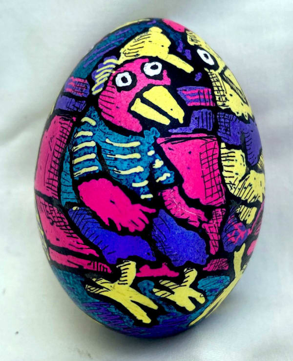 dyed egg showing bright pink, blue and yellow bird sitting on subway bench