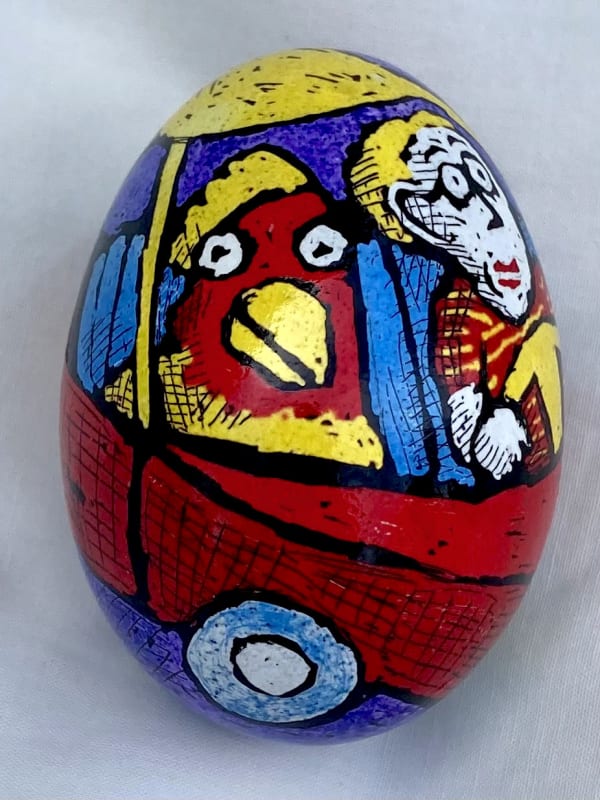 Pysanky egg showing bird and man in a car
