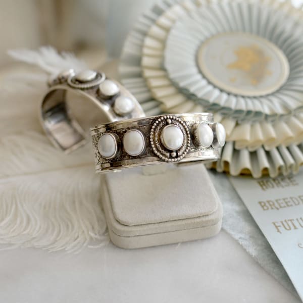 Jill Garber, A Lovely floral ¾” band with elaborate embossed floral detailing forms the foundation of this freshwater pearl cuff bracelet