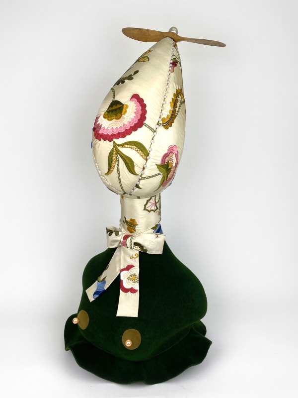 An upholstered sculpture of a bust with gold nipples and a floral face and neck tie by artist Ryan Wilde.