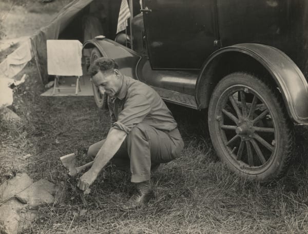 [Auto-Camping], Driving Down Peg for Tent, c. 1920