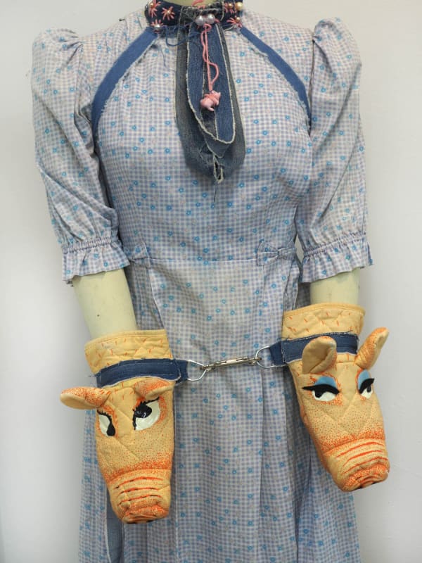 Samantha Joy Groff Piggy Cuffs and Collar, 2021 Oven mitts, denim, puff paint, beads, d-rings and clip 152.4 x 45.7 x 38.1 cm
