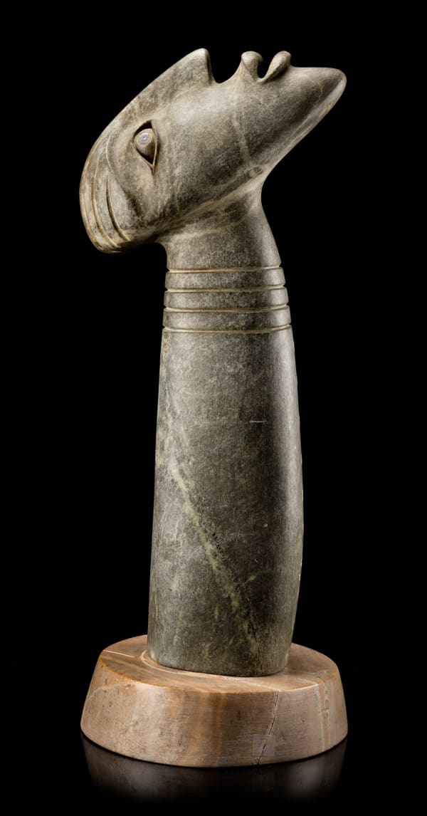 Lot 53 DAVID RUBEN PIQTOUKUN (1950-) PAULATUK / ONTARIO Monumental Head Emerging from Stone, 1997 stone and muskox horn, 25 x 9 x 9.25 in (63.5 x 22.9 x 23.5 cm) ESTIMATE: $4,000 — $6,000 Price realized: $8,540.00