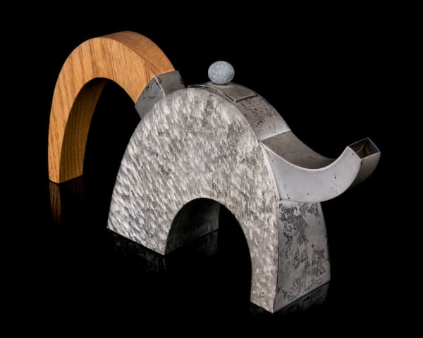 Lot 30 MICHAEL MASSIE, C.M., R.C.A. (1962-) KIPPENS, NEWFOUNDLAND AND LABRADOR Bounce (Teapot #28), 1998 sterling silver with spiral finish, oak, and beach pebble, 5.25 x 10.5 x 2.5 in (13.3 x 26.7 x 6.3 cm) ESTIMATE: $6,000 — $9,000