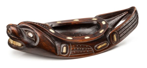 Lot 56 POSSIBLY RUDOLPH WALTON (1867-1951) OR A FOLLOWER, TLINGIT, SITKA, ALASKA Seal Form Grease Bowl, c. 1920 wood, stain, abalone, bone, and glass beads, 4 x 16 x 7 in (10.2 x 40.6 x 17.8 cm) ESTIMATE: $4,000 — $6,000 price realized: $5,124.00