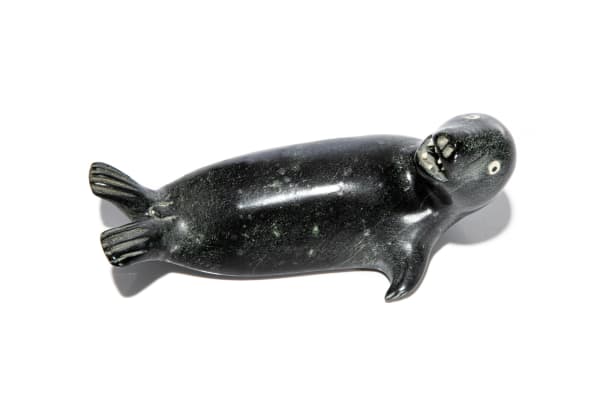 Lot 18 JUDAS ULLULAQ (1937-1999) UQSUQTUUQ (GJOA HAVEN) Seal Looking Back, mid-late 1980s stone and antler, 3.25 x 7.25 x 3.5 in (8.3 x 18.4 x 8.9 cm) PRICE REALIZED: $615.00