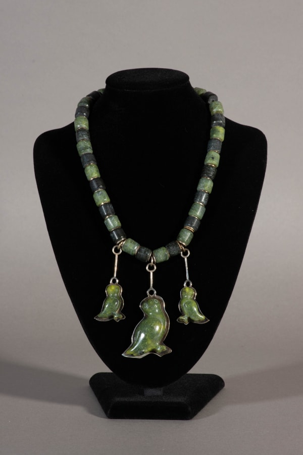 10 PAPIARA TUKIKI (1942-2023) KINNGAIT (CAPE DORSET) Necklace with Three Birds, c. 1975 the necklace: stone, sterling silver, and cord, total length: 16.5 in (41.9 cm)