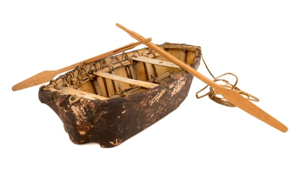 Lot 14 UNIDENTIFIED ARTIST, KUUJJUAQ (FORT CHIMO) Model Umiak, c. 1960 sealskin, bone, and wood, vessel: 20 x 9 x 4 in (50.8 x 22.9 x 10.2 cm) / each paddle, length, 17 in (43.2 cm) ESTIMATE: $500 — $800 PRICE REALIZED: $268.40