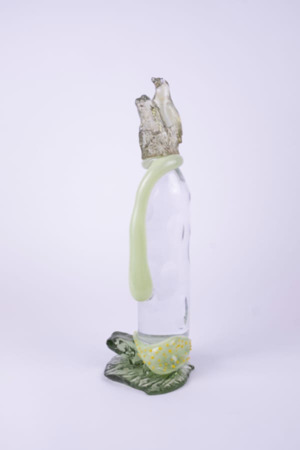 Rasmus Nossbring glasskulptur med två gröna fåglar sittande på en grön rinnande droppe på en klarglas form ovanpå en grön groda.