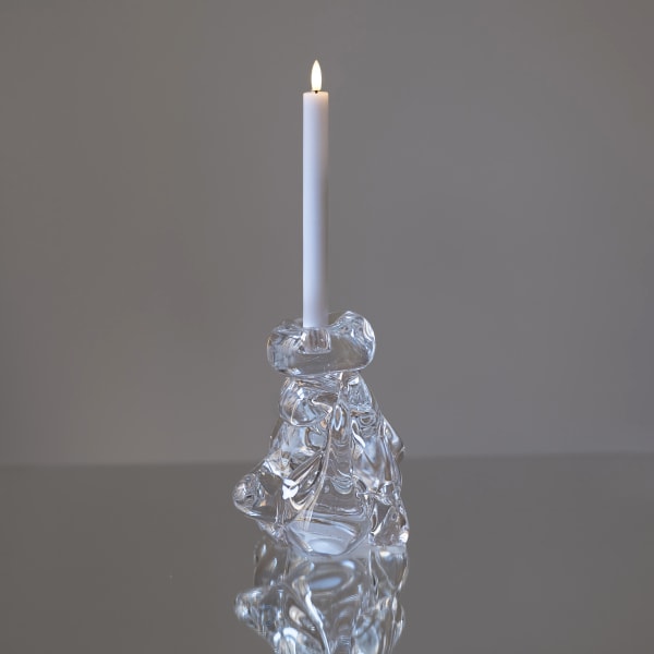 ljusstake i rinnande glas med ett ljus i