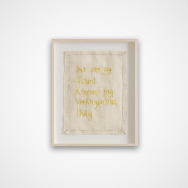 vit tavla med gul broderad text där det står det som jag glömt kommer jag verkligen inte ihåg