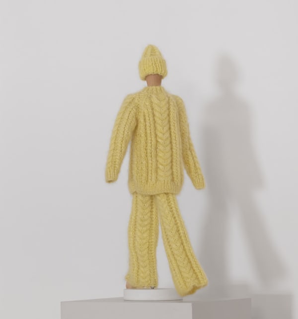 trädocka med stockade byxor, tröja och mössa i gult