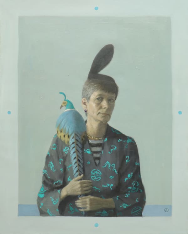 Woman sitting with blue and yellow pheasant on shoulder