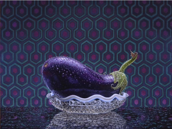 Still life of an eggplant in a glass bowl with a tiled background