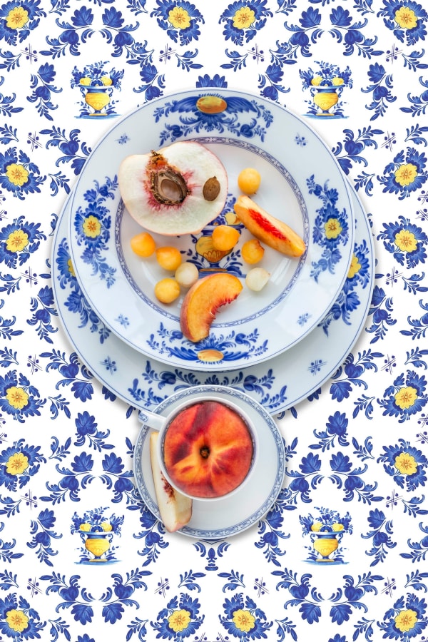 peaches artfully laying on heirloom plates in blue by jp terlizzi