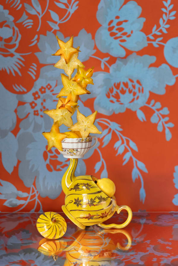 yellow teapot and star shaped lemons stacked on spout