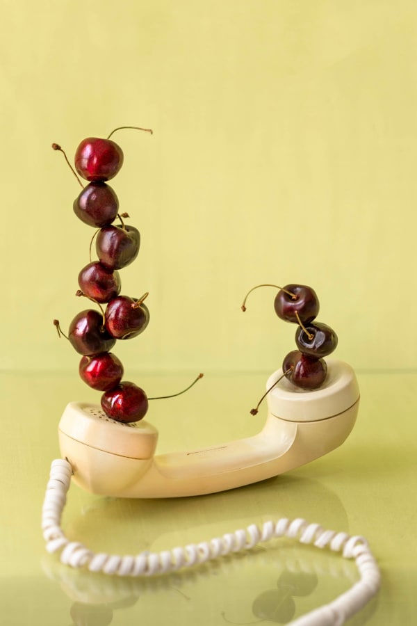 cherries stacked on handset of phone