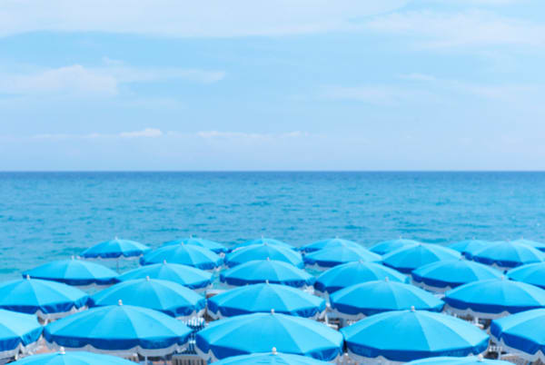 blue umbrellas and ocean photo by Laurie Victor Kay