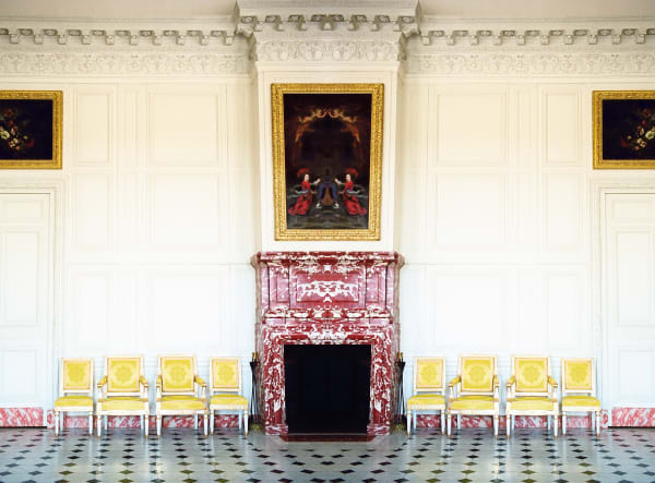photograph of yellow chairs on either side of marble fireplace versaiile