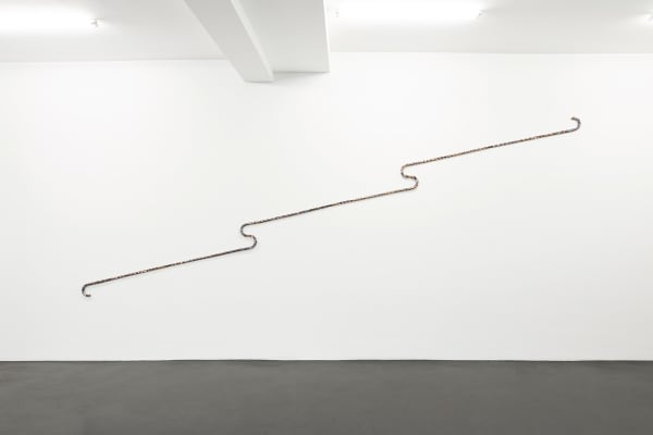 Wall fixture comprised of three connected walking sticks covered in a collage of contact prints.