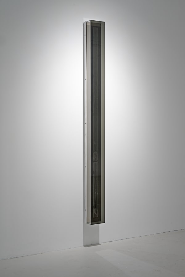 A mixed media piece hanging on a white wall.