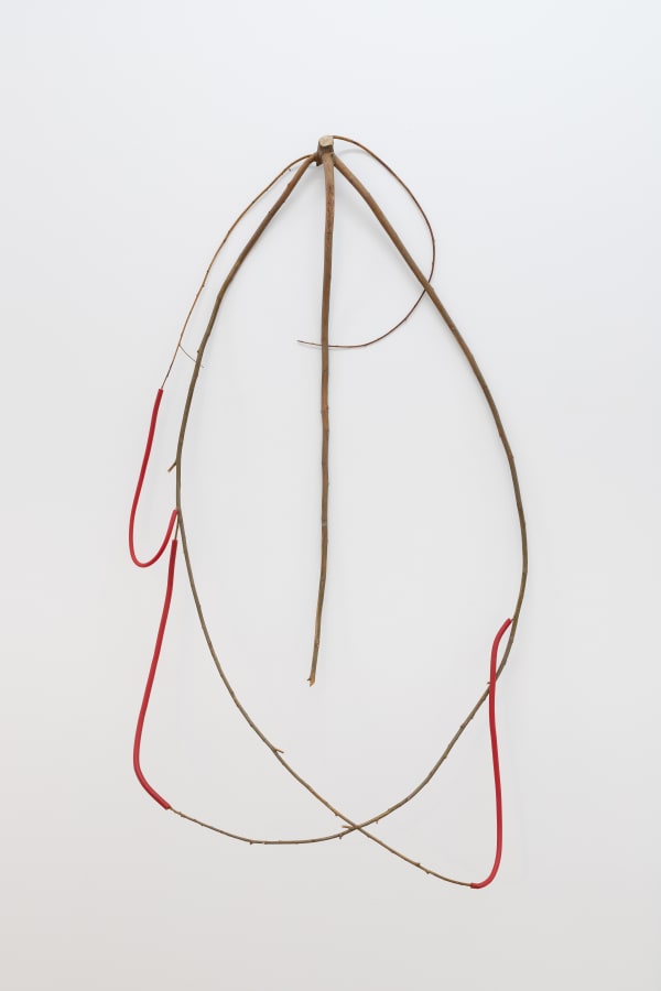 a spindly wall-mounted sculpture made of wood and wax