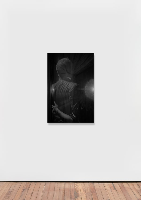 A black and white inkjet print of a shadowy figure.
