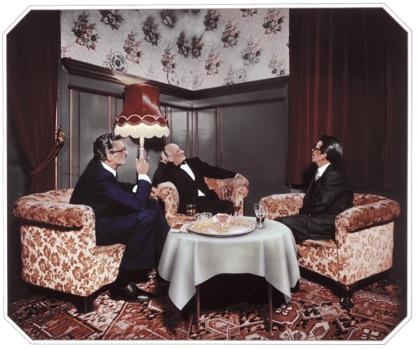 Retouched vintage photograph of three suited men lounging and smoking in a parlor.