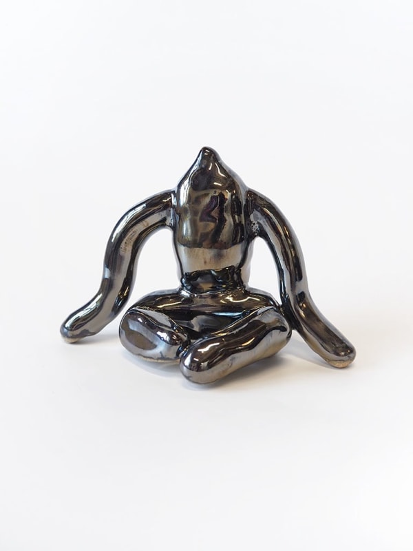 ceramic piece by Jocelyn Tsaih of a silver figure sitting