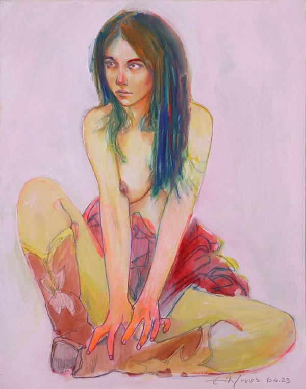 topless woman in cowboy boots and a skirt seated on the ground with her hands at her feet looking off to the side