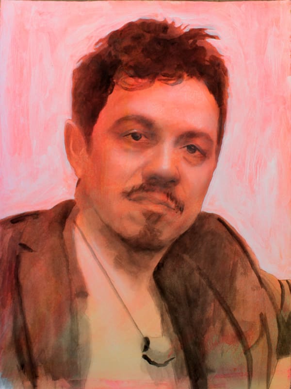 Portrait of a man with facial hair, dark hair and eyes with a open coat and a long necklace on an orange background.