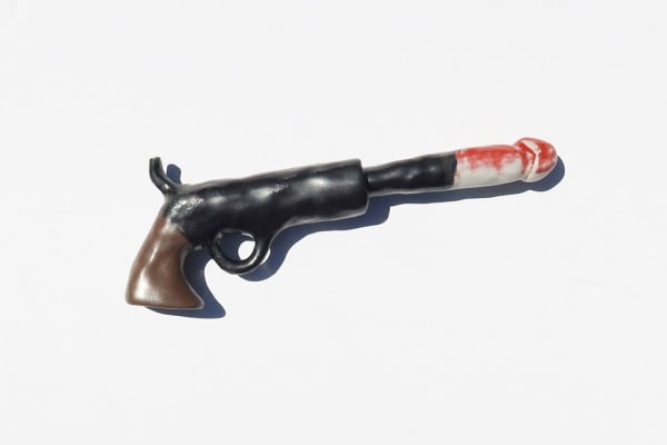 ceramic sculpture of a gun with a penis coming out of the barrel