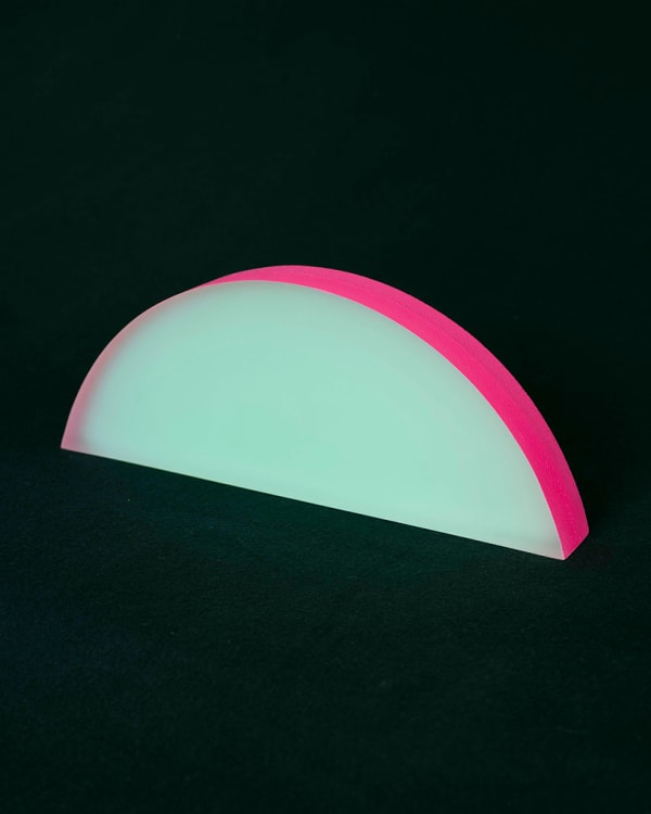 Rachel Strum - epoxy neon sculpture of horizontal strip of a round panel top edge - green and hot pink.