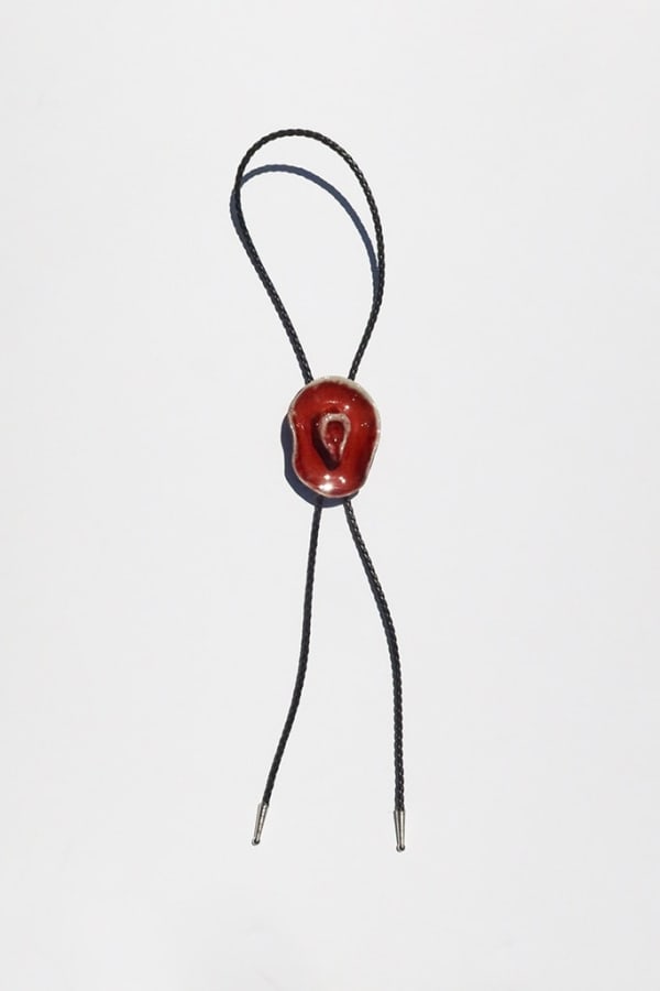 Ceramic bolo tie of a red cowboy hat on a black leather tie