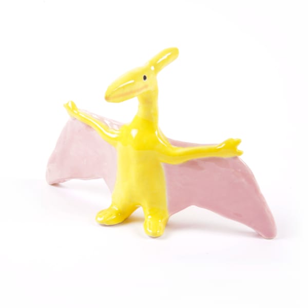 miniature ceramic sculpture of a yellow flying dinosaur