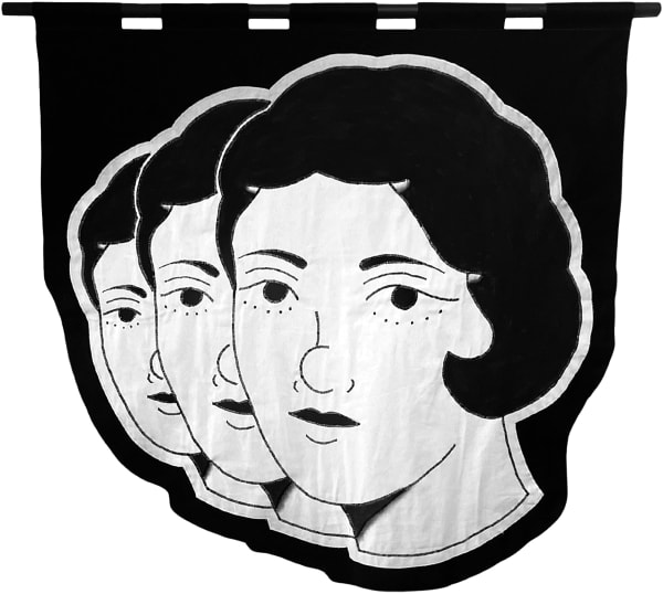 embroidered black and white banner of the heads of three woman in an angled row