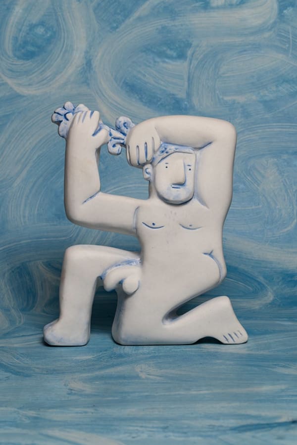 sculpture of a man kneeling with water coming out from his head