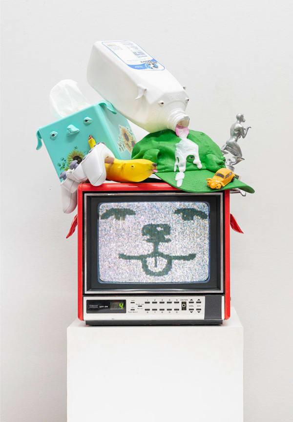 red vintage tv showing a static-y cartoon dog face with various household objects stacked on top with dog face